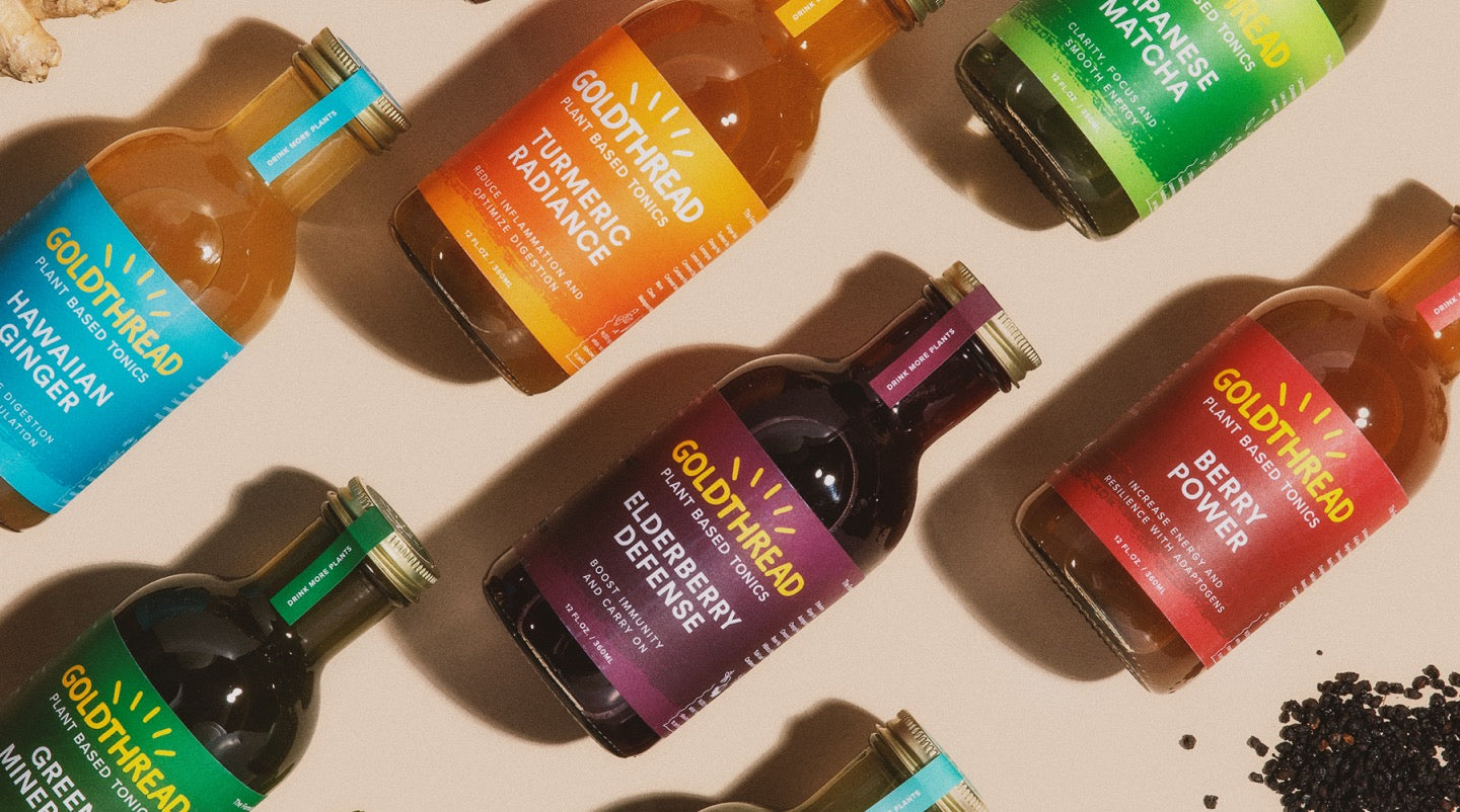 A variety of colorful Goldthread drink bottles arranged on a flat surface, including flavors like Turmeric Radiance and Elderberry Defence.