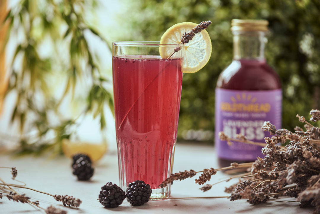 Goldthread Plant-Based Tonics Lavender Lemon Tonic Cocktail garnished with lemons and blackberries