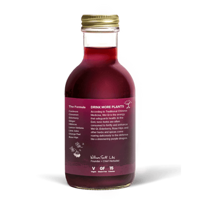 A glass bottle with a gold cap containing 10.5 fl oz (300 ml) of purple liquid. The purple label identifies the drink as Goldthread's Elderberry Defense plant-based tonic and features text reading "Boost Immunity and Carry On".